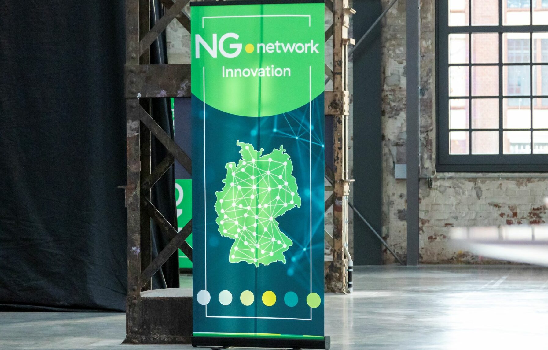 Der Banner "NG.network Innovation" in einer Halle.