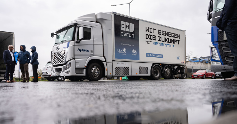 Wasserstoff-LKW fotografiert von der Seite mit spiegelnder Wasserpfütze